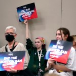 A supporter holds up a sign that reads 