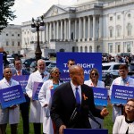 Sen. Cory Booker speaks during a news conference on access to IVF treatments outside of the Capitol Building. He is surrounded by doctors holding signs that read 