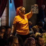 A demonstrator holds a sign reading 