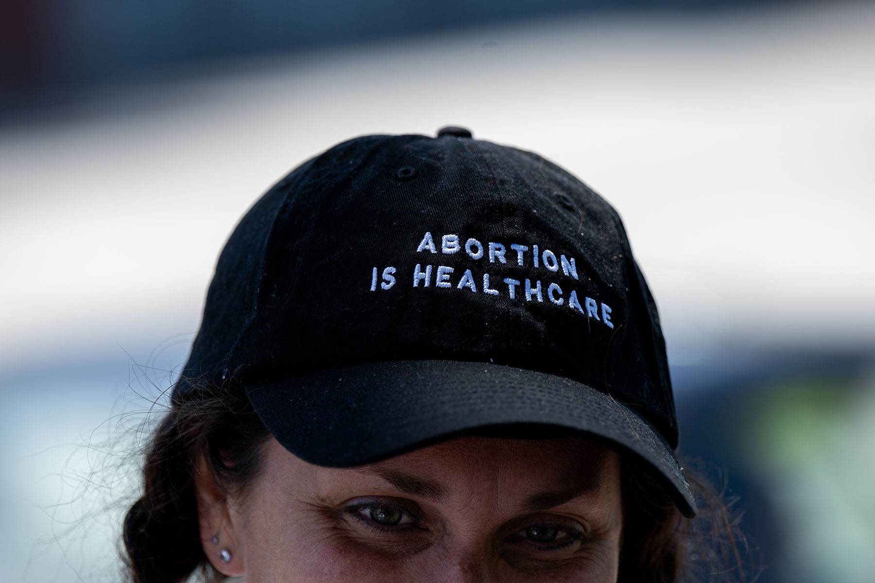 A volunteer wears a hat that reads "abortion is healthcare" at a petition signing event.