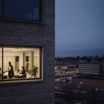 Multiracial female colleagues working late seen through window of work place.