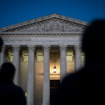 Silhouettes are seen in front of the U.S. Supreme Court.