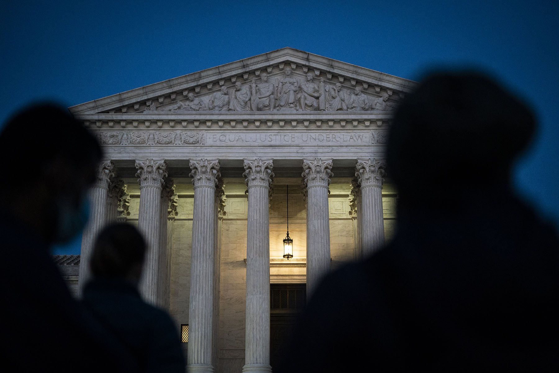 Silhouettes are seen in front of the U.S. Supreme Court.