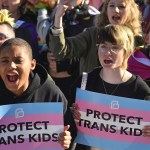 Protesters of Kentucky Senate Bill SB150 cheer on speakers and hold signs up that read 