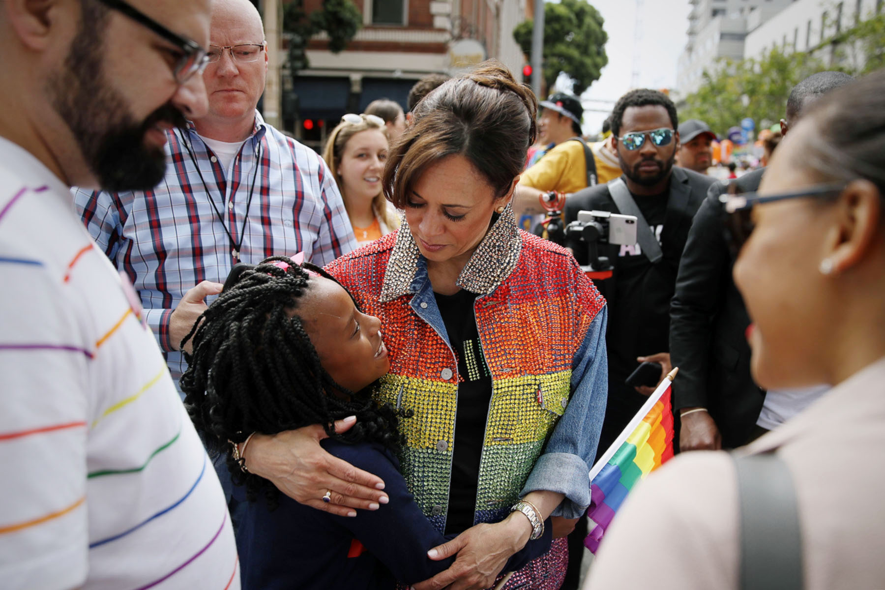 Kamala Harris sported a rainbow colored jacket as she hugs a young supporter before the start of the SF Pride Parade in San Francisco.