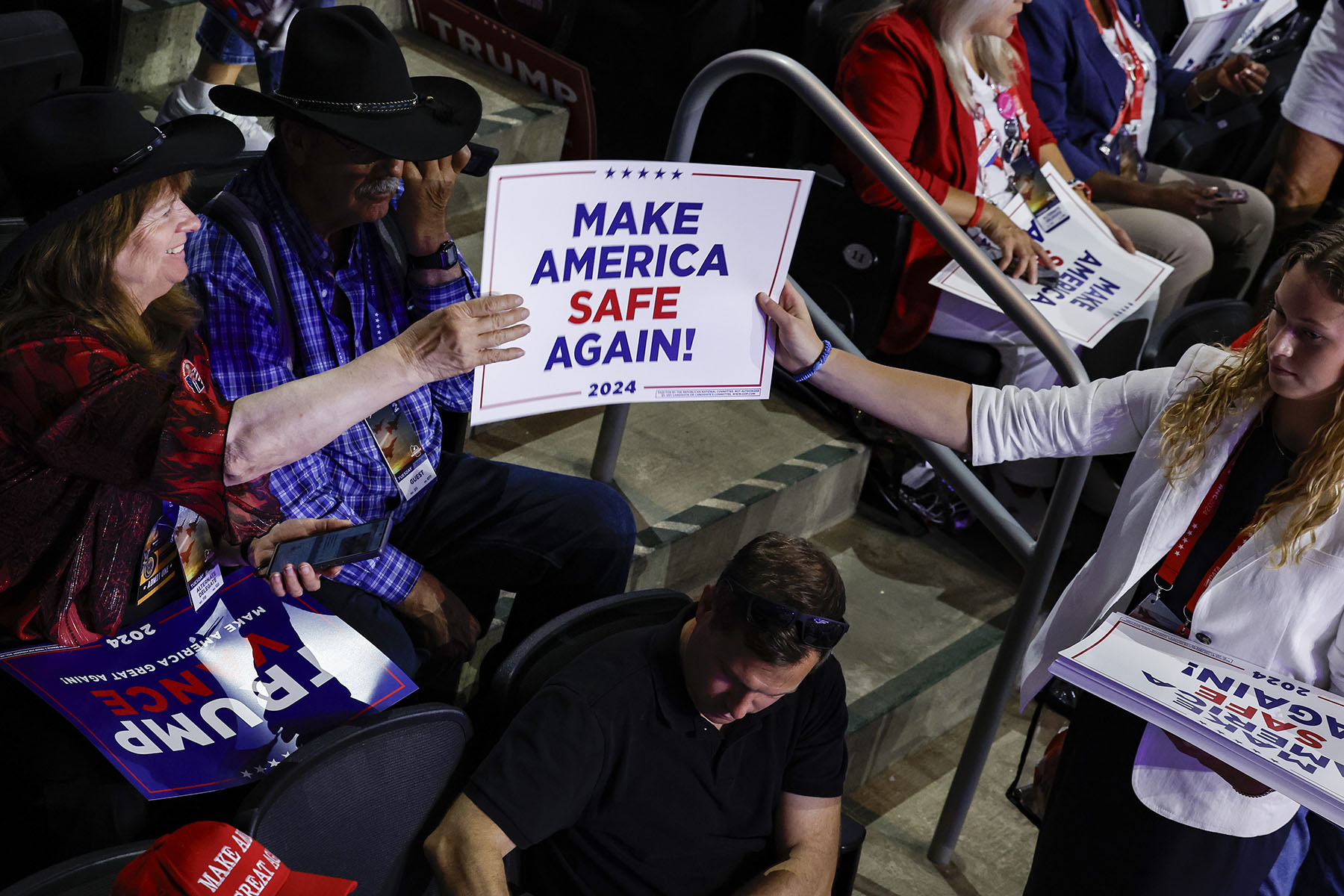 A convention worker hands out "Make America Safe Again!" signs on the second day of the Republican National Convention.