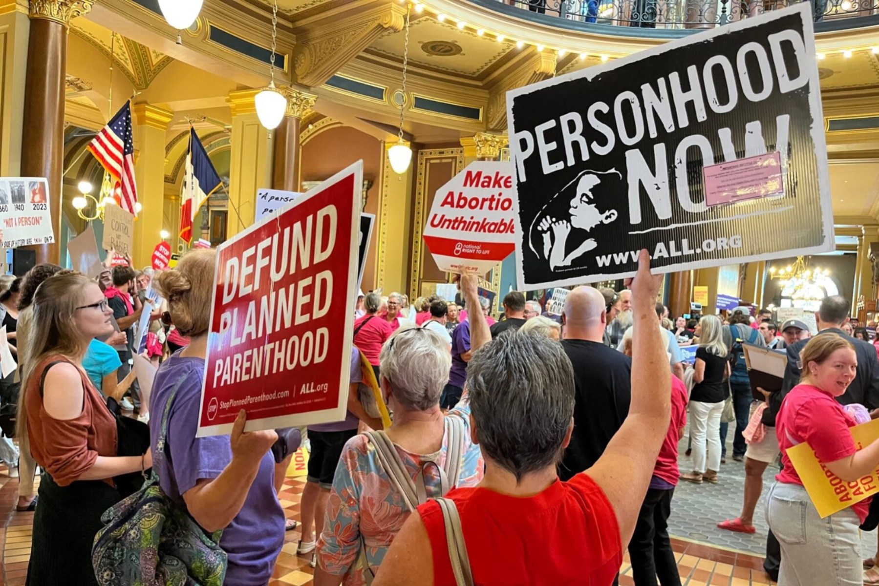 People holding anti-abortion signs at the Iowa Capitol.