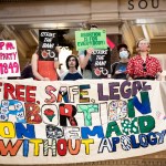 Planned Parenthood advocates protest at the Wisconsin State Capitol. Signs read 