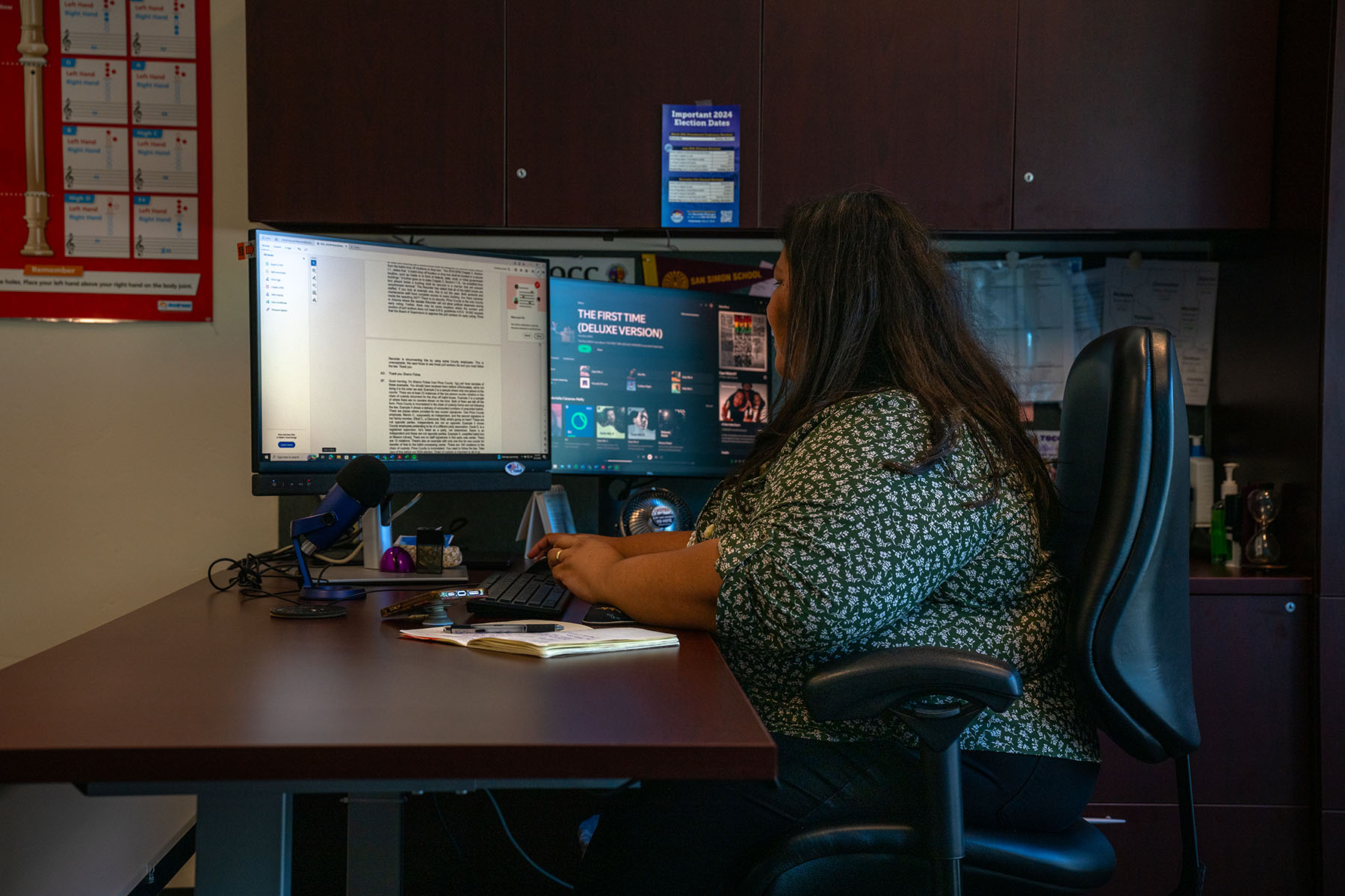 Gabriella Cázares-Kelly sits at her office desk, typing on a computer.