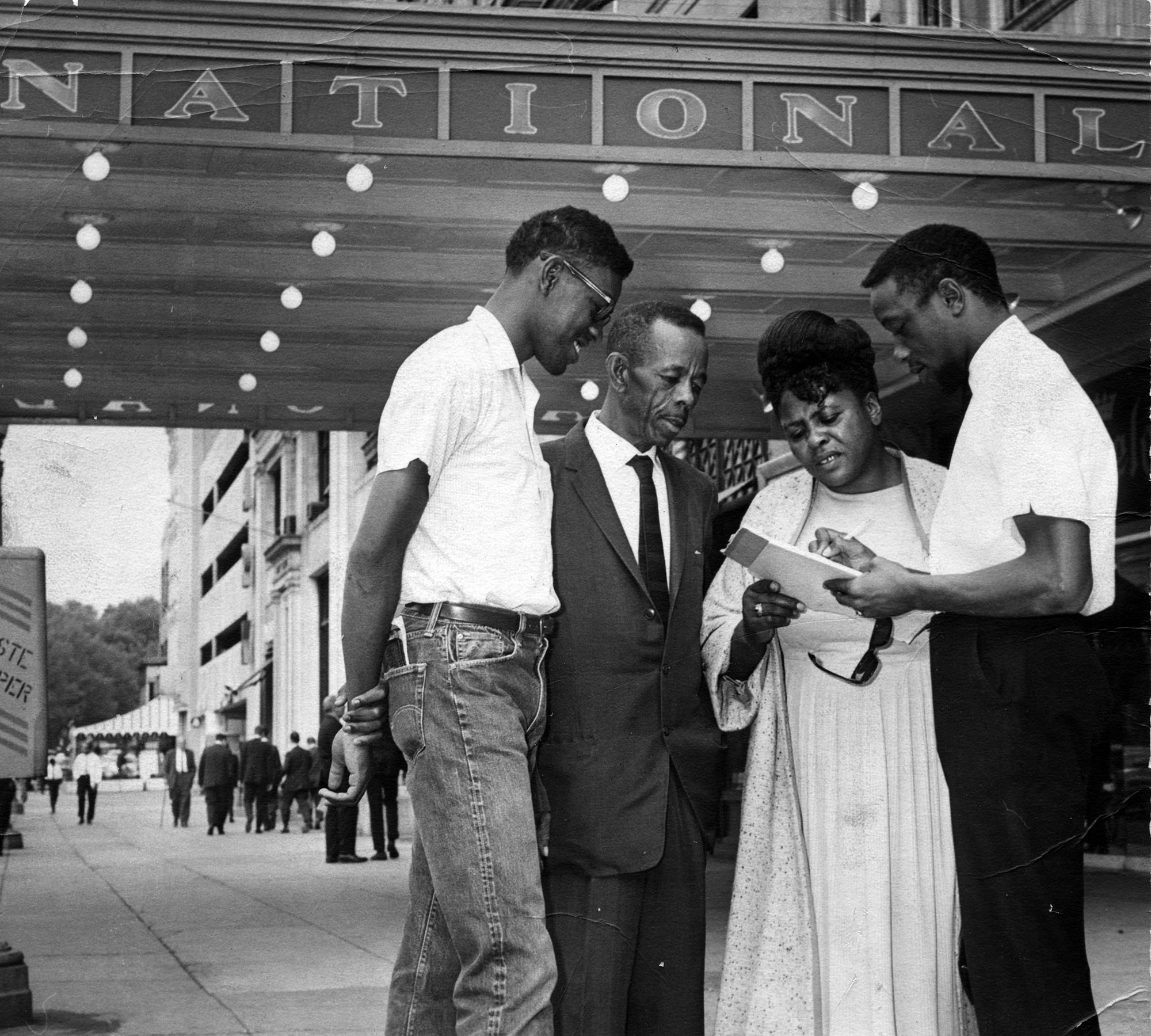 A three quarter length portrait of civil rights leader Fannie Lou Harmer with three men