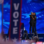 Former President Barack Obama hugs former first lady Michelle Obama as he arrives to speak on stage.