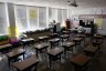 Desks are seen in an empty elementary school classroom.