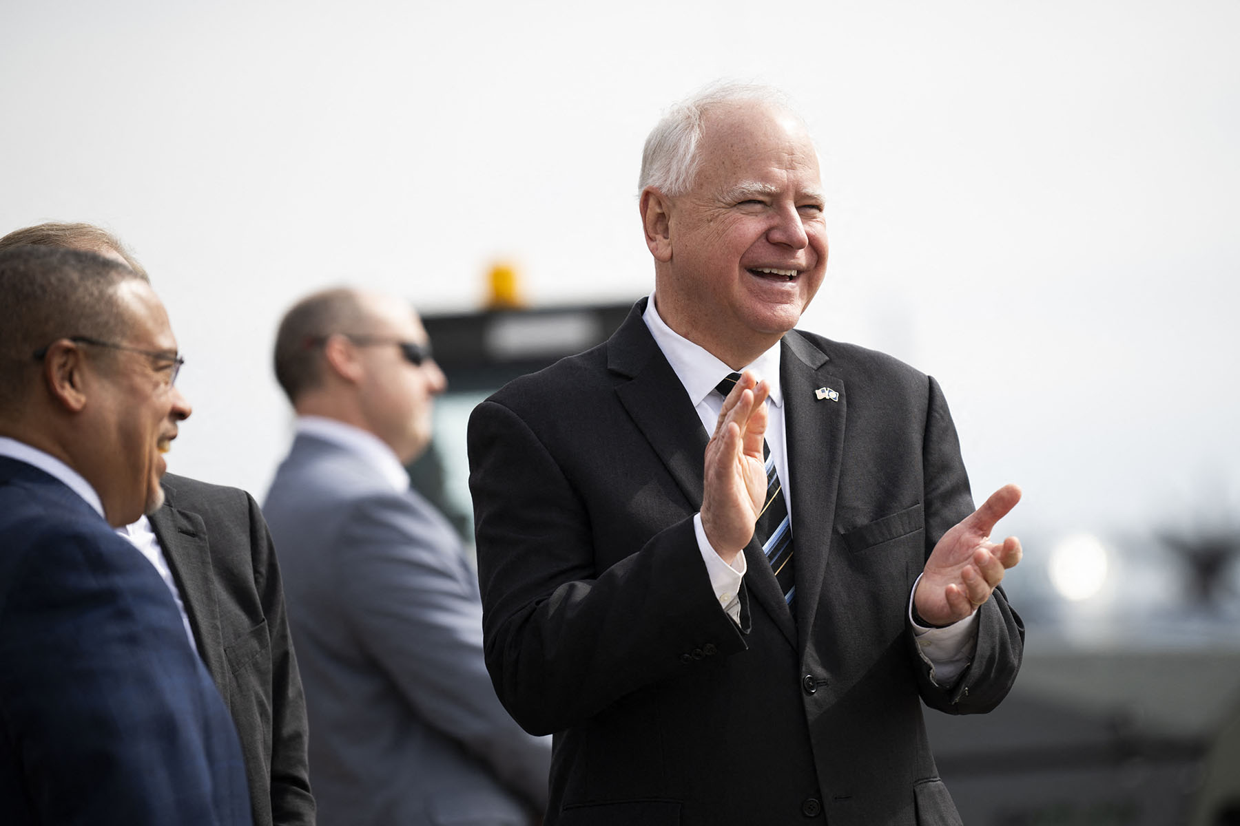 Minnesota Gov. Tim Walz smiles as he awaits the arrival of Vice President Kamala Harris at the Minneapolis-St. Paul International Airport.