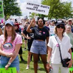 A group of protesters in Georgia holding signs supporting abortion rights. One woman holds a sign reading 'Abortion rights are human rights,' while others around her display messages opposing the overturning of Roe v. Wade.