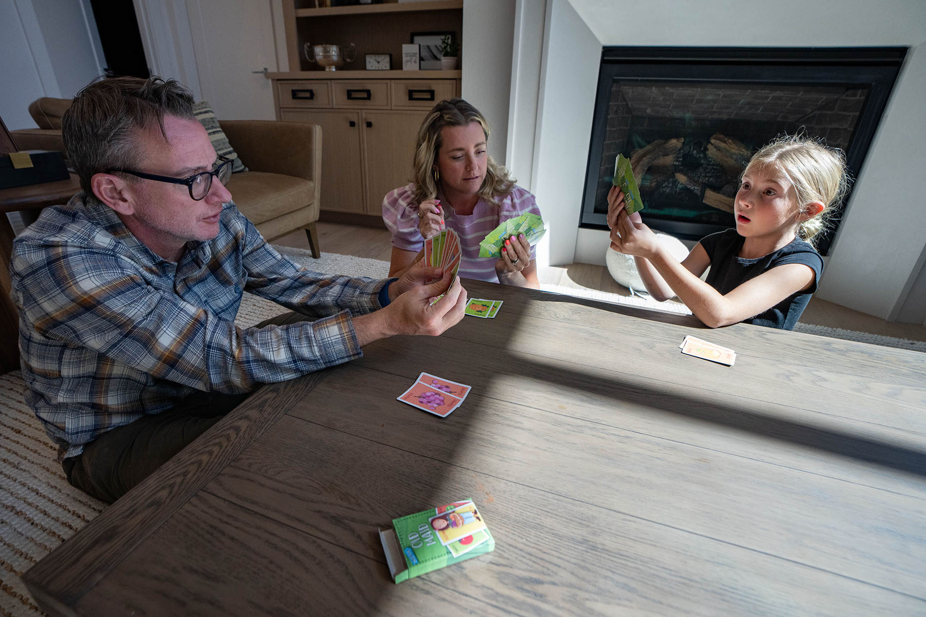 Travis Smith, running for Utah House District 42, plays cards with wife Tillia and their daughter Margot, 7.