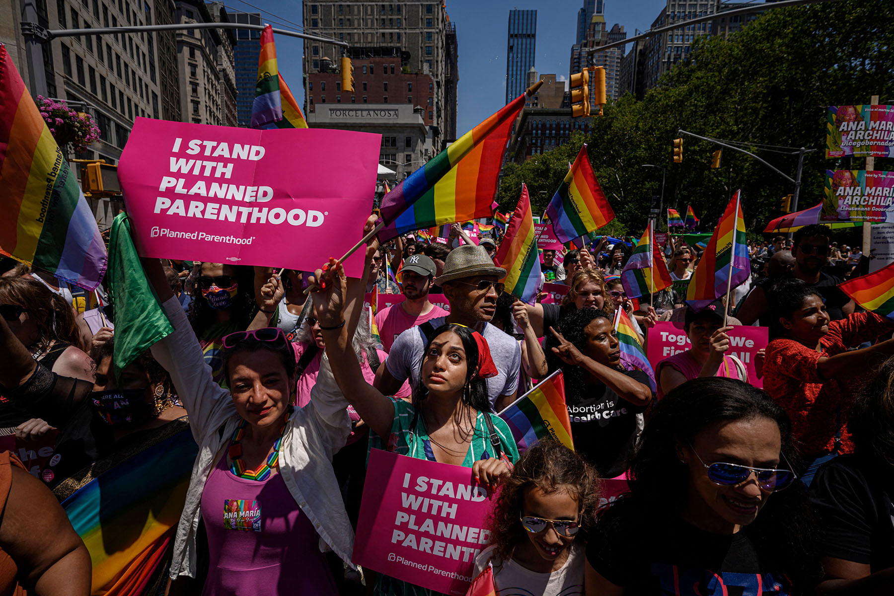 Participants holding pride flags and signs that read "I Stand with Planned Parenthood" march during the New York Pride Parade in New York City.