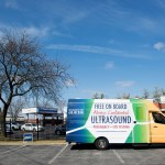 A crisis pregnancy center mobile clinic van is parked adjacent to a Planned Parenthood Center in Fairview Heights, Illinois.