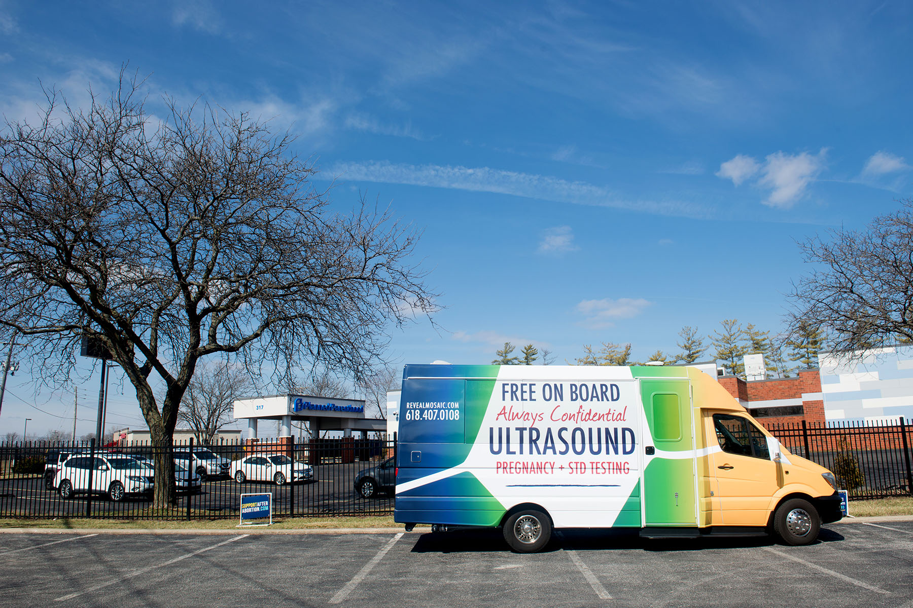 A crisis pregnancy center mobile clinic van is parked adjacent to a Planned Parenthood Center in Fairview Heights, Illinois.