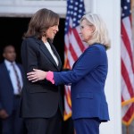 Two women embrace on a stage.