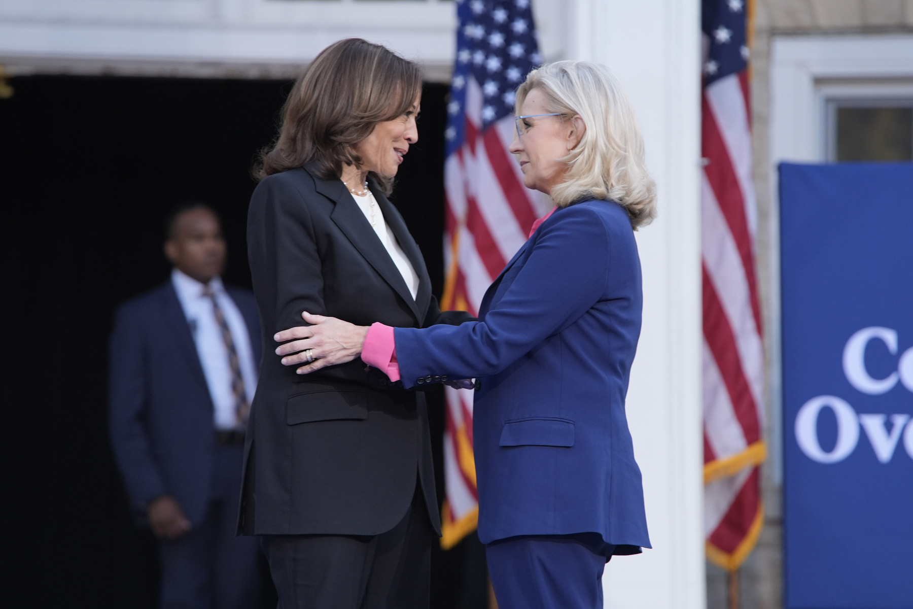 Two women embrace on a stage.