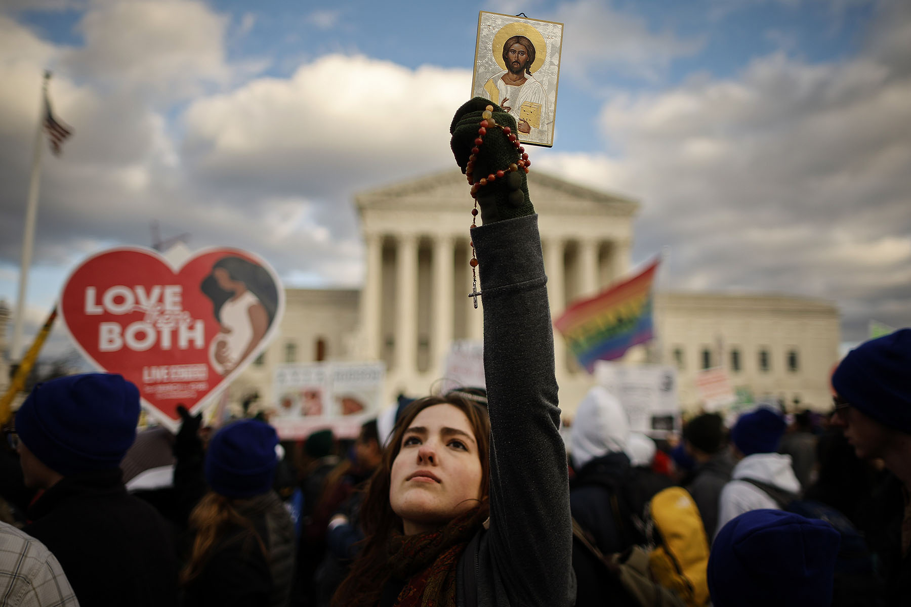 A large crowd gathers on the National Mall, holding signs and banners advocating for anti-abortion causes, with the U.S. Supreme Court visible in the background.