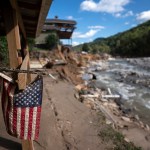 A tattered American flag is seen on a property amongst flood damage in the aftermath of Hurricane Helene in North Carolina