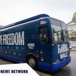 A blue Harris-Walz campaign bus with the slogan 'Fighting for Reproductive Freedom' painted on is parked outside the Pennsylvania State Capitol in Harrisburg.