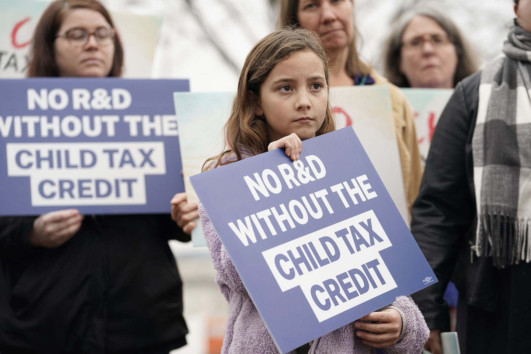 A child hold a sign during a press conference on Child Tax Credit on Capitol Hill.