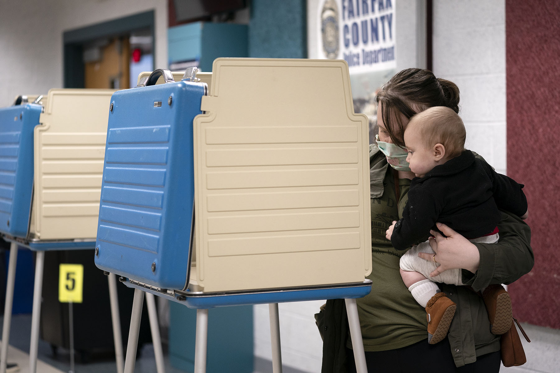 A mother accompanied by her six month old son fills out her ballot at an early voting center in Alexandria, Virginia.