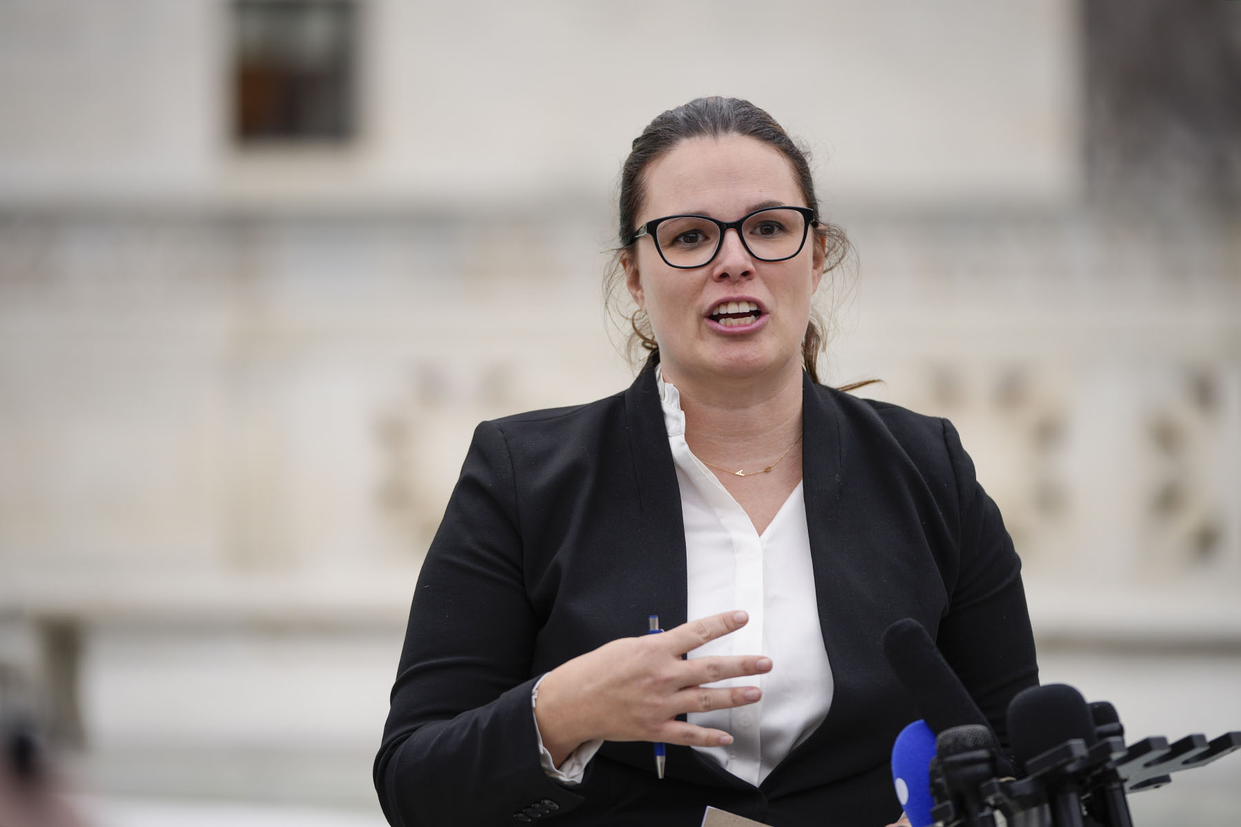 Allison Riggs talks to reporters outside the U.S. Supreme Court.