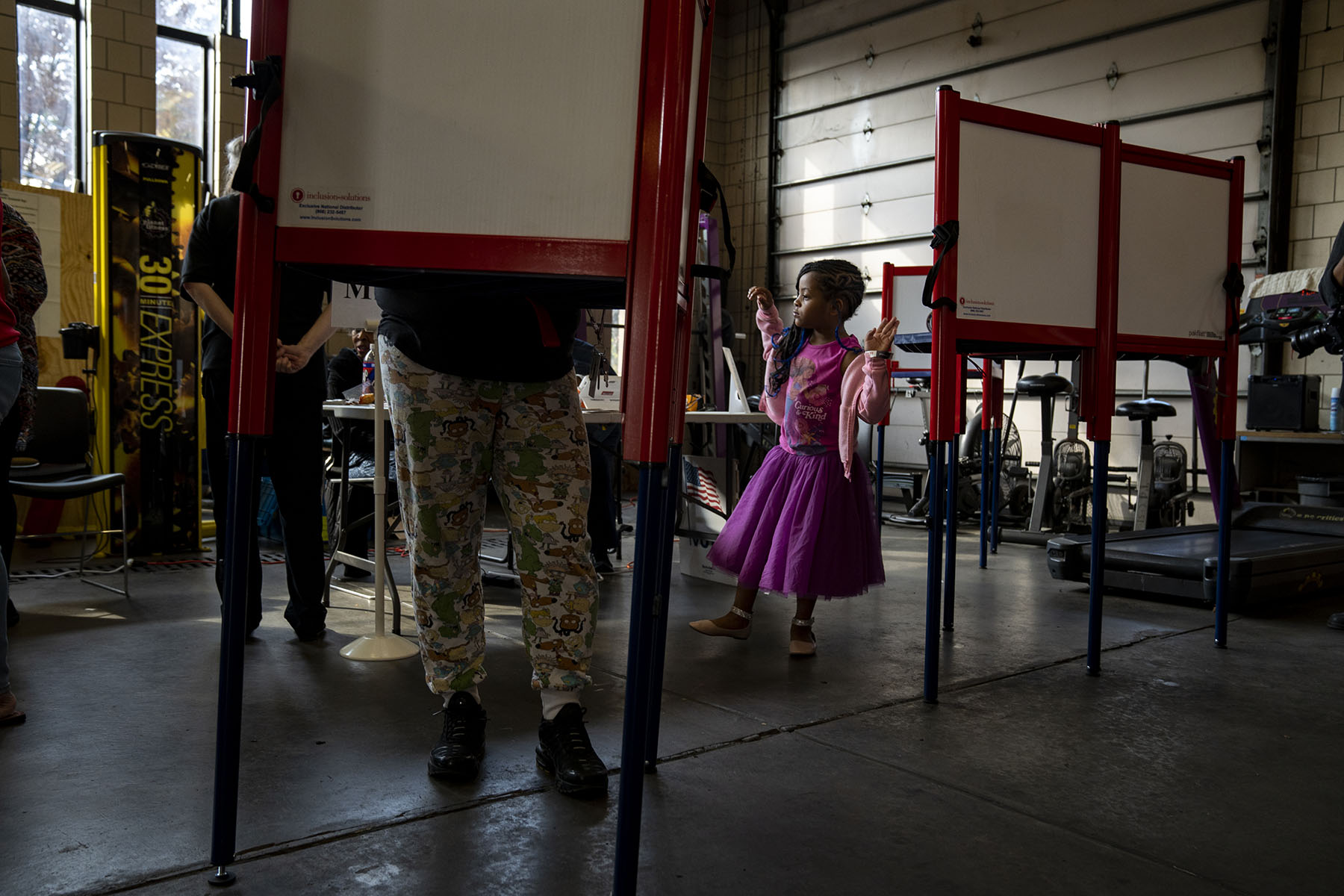 A voter fills out her ballot at a fire station while her daughter waits for her in Louisville, Kentucky.