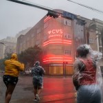 A group of people cross an intersection in New Orleans, Louisiana, during Hurricane Ida.