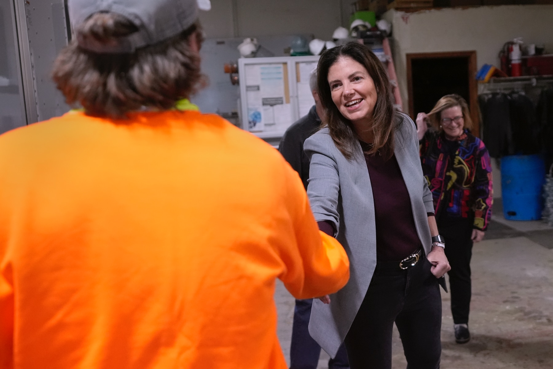 Republican gubernatorial candidate Kelly Ayotte shakes hands with a worker at a concrete coating business