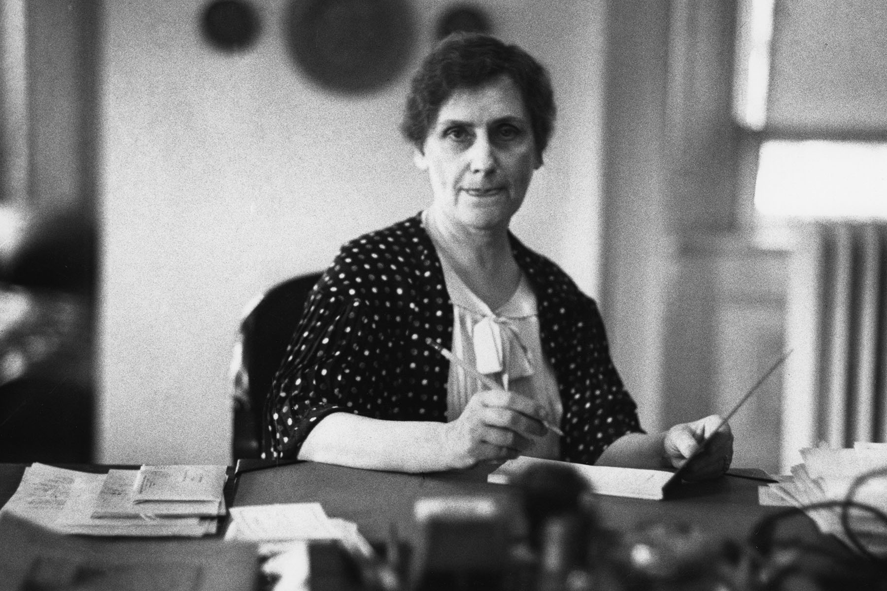 Nellie Tayloe Ross seated at her desk at the Office of the Treasury as Director of the United States Mint.