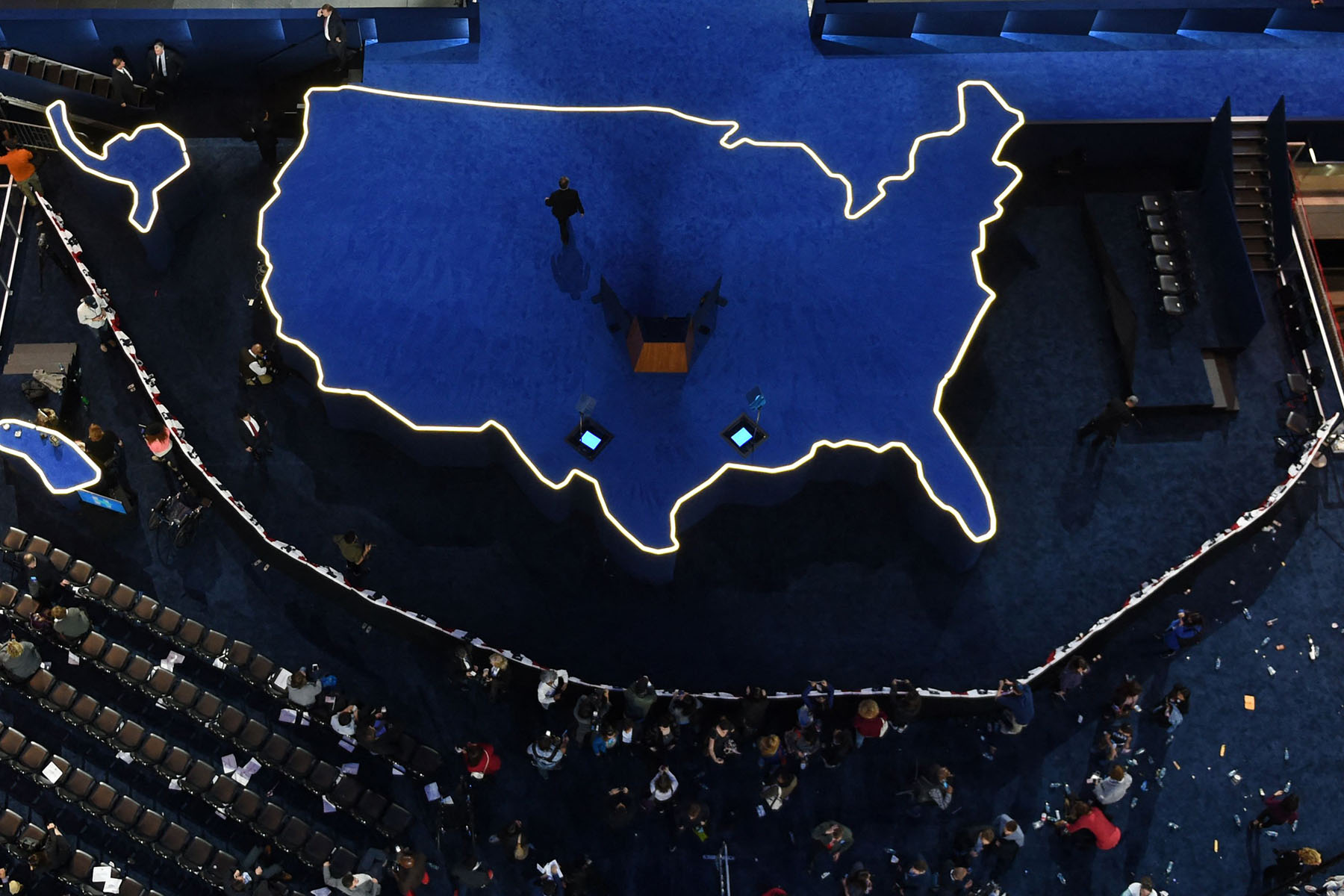 A man walks off an empty stage shaped like the United States, after Hillary Clinton did not arrive to speak during election night at the Jacob K. Javits Convention Center in New York City