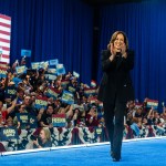 Vice President Kamala Harris takes the stage during a campaign rally at in Harrisburg, Pennsylvania. Behind her, the crowd hold up signs that read 