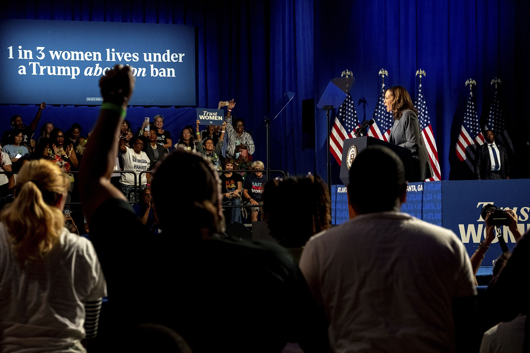 Vice President Harris speaks to supporters in Atlanta, Georgia about reproductive freedom and Trump abortion bans. A sign reads "1 in 3 women lives under a Trump abortion ban."