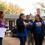 Activists look at a phone as they to collect signatures in a neighborhood in Crete, Nebraska.