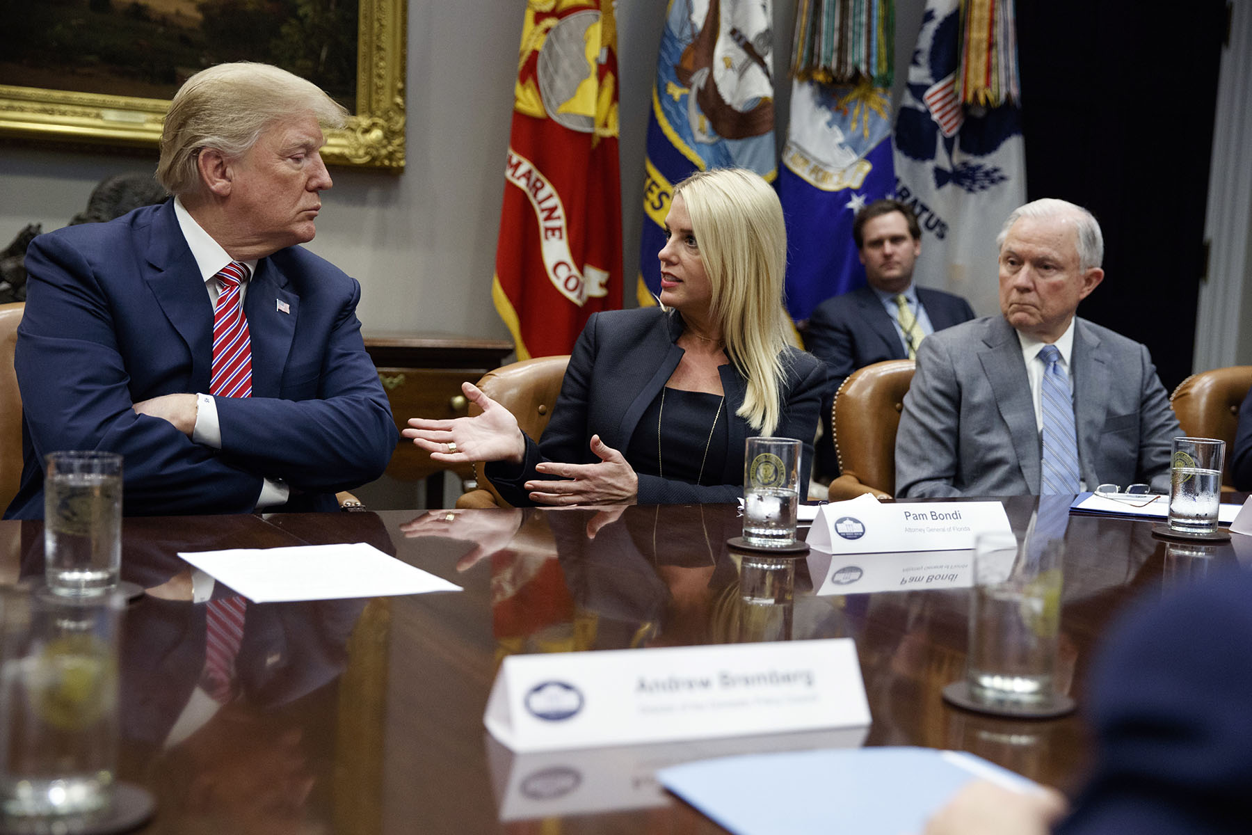 President Donald Trump and former Attorney General Jeff Sessions listen as then-Florida Attorney General Pam Bondi speaks in the Roosevelt Room of the White House.