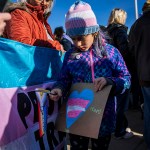 A non-binary child attends a protest outside the Supreme Court during the United States v. Skrmetti arguments.