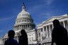 Silhouetted figures walk past the U.S. Congress building.