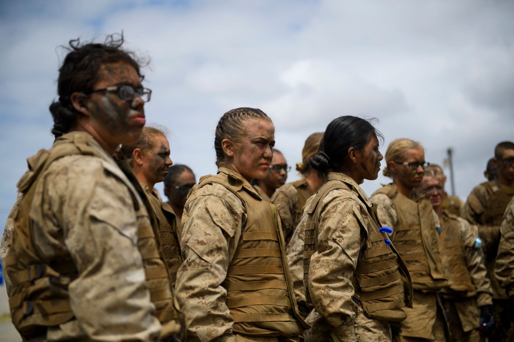 A group of female Marines stand in a line together in uniform.