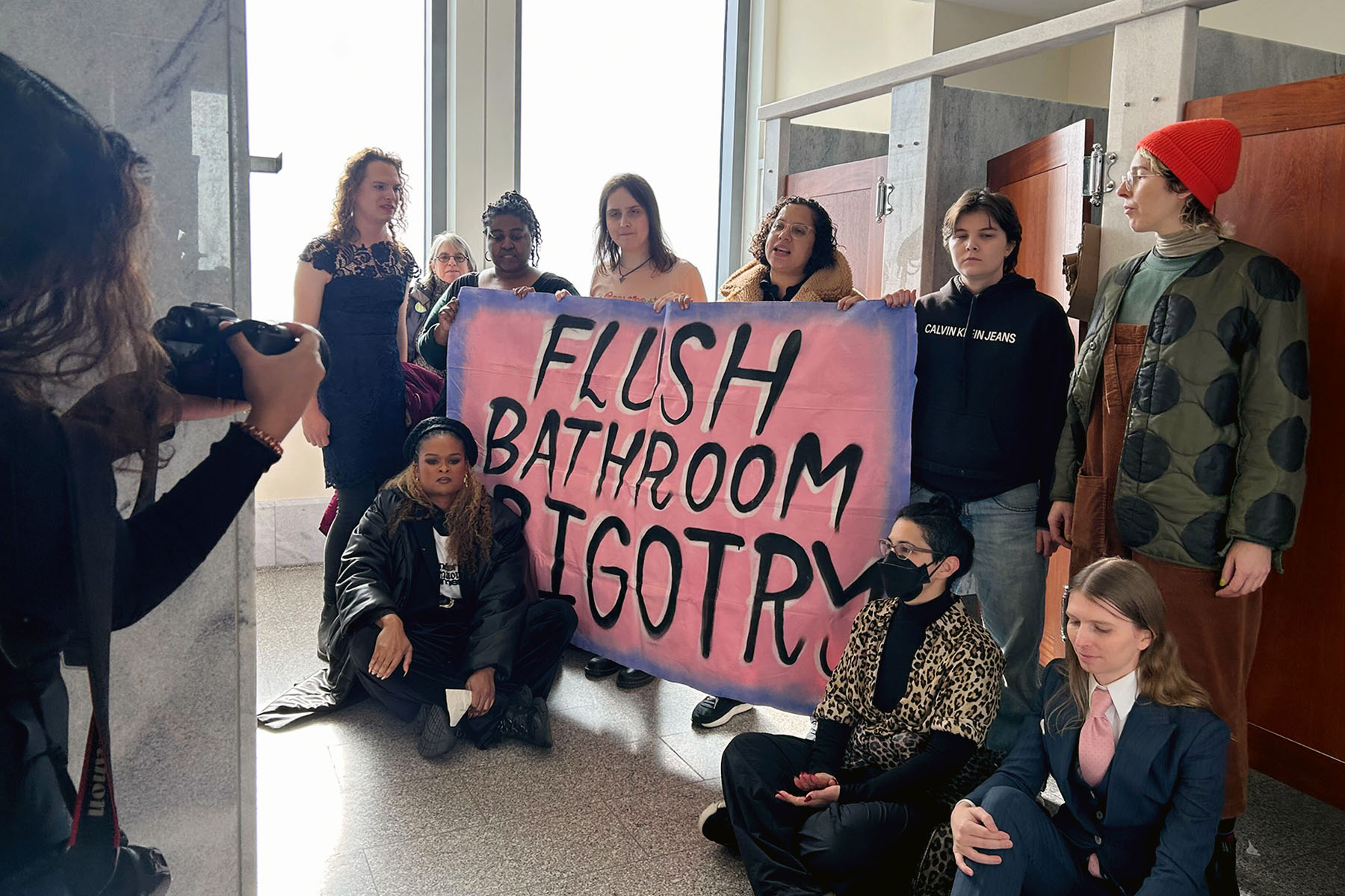 Protesters with Gender Liberation Movement, including Chelsea Manning (far right) and Racquel Willis (bottom left) sit inside the congressional bathroom closest to House Speaker Mike Johnson’s office.