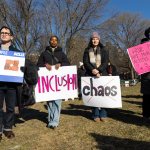 Young people stand together and hold signs the Boston Common.