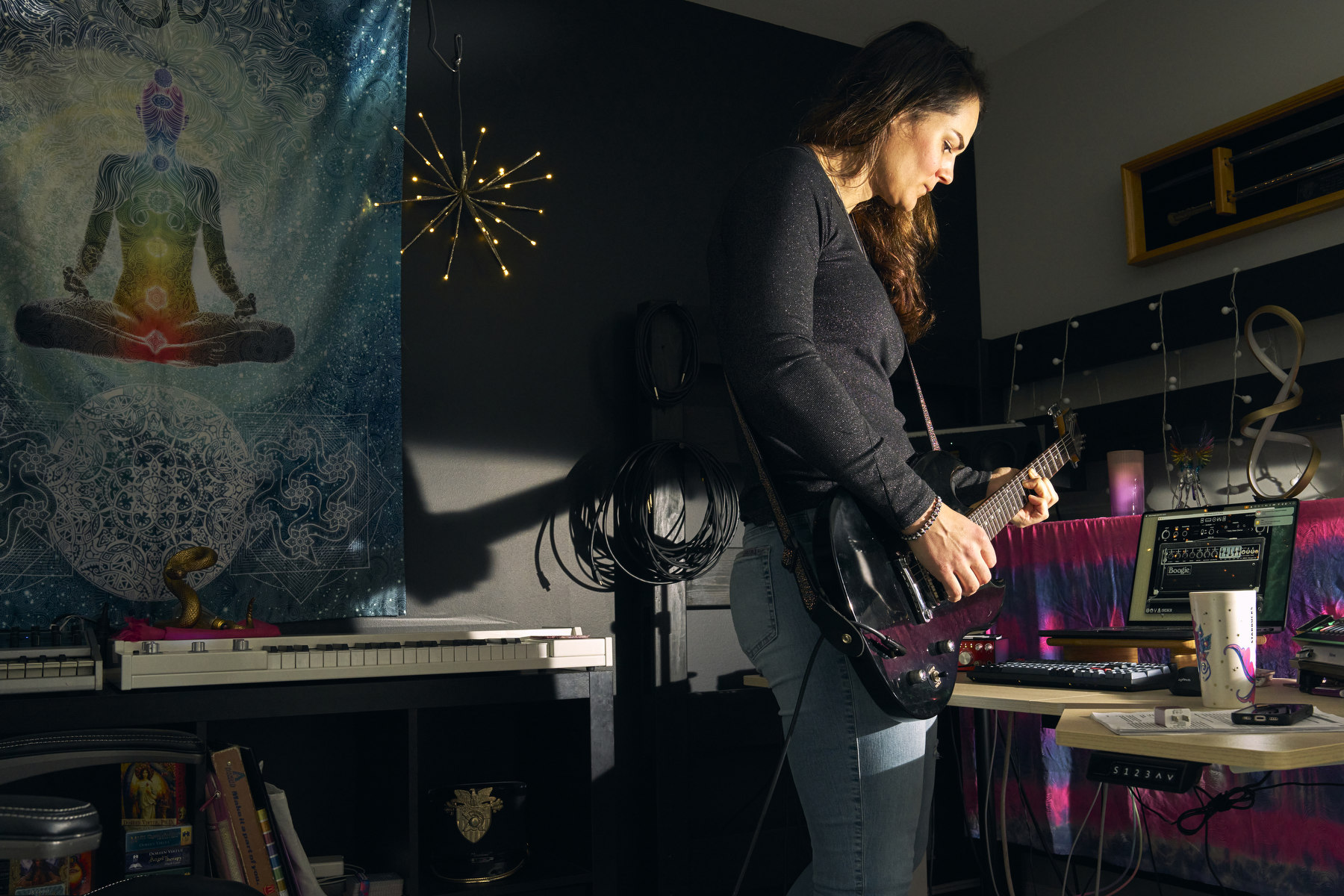 A woman plays guitar surrounded by musical instruments.
