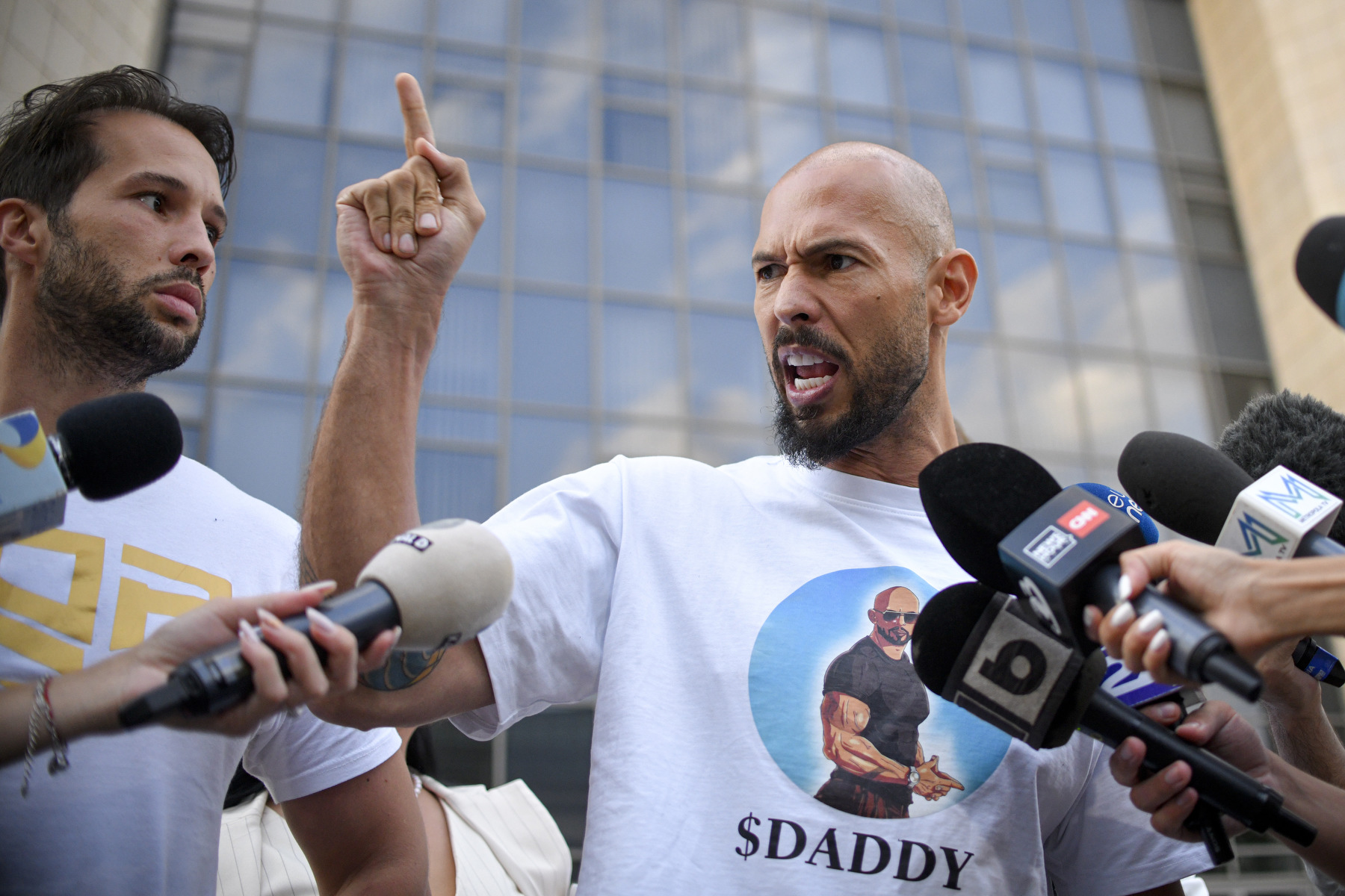 A man points angrily in front of cameras.