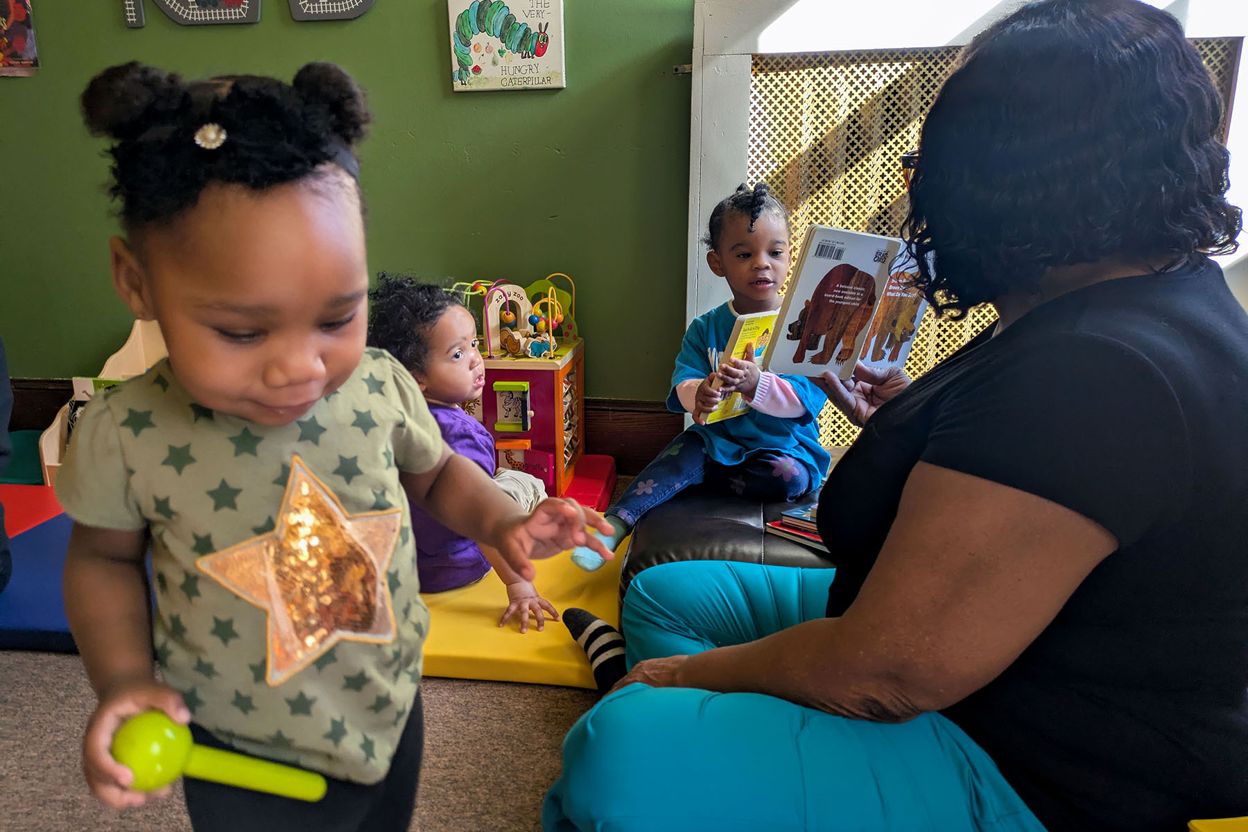 MiaRose Younan enjoys story time with Sandra Dill at Dill’s home child care business in New Haven.