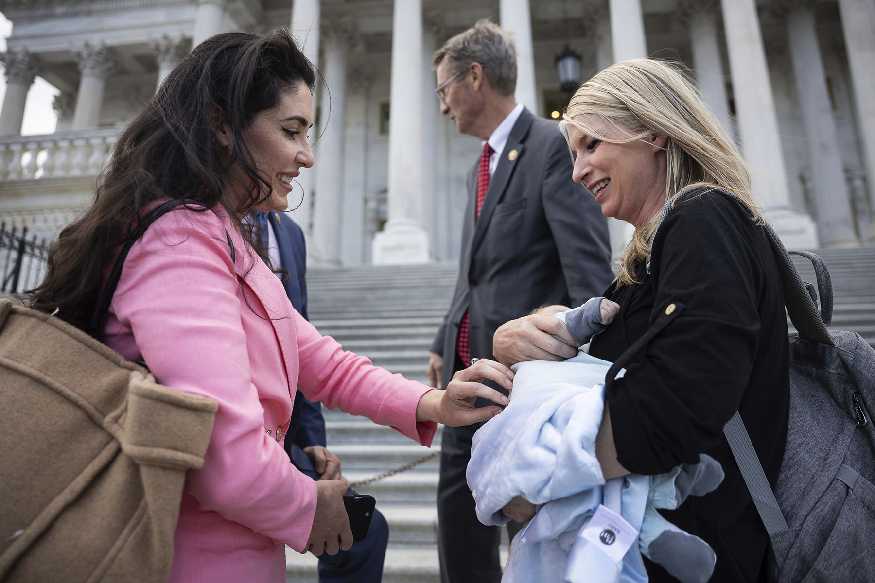 Rep. Anna Paulina Luna greets Rep. Brittany Pettersen and her infant son, Sam, outside the Capitol.