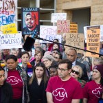 A large crowd gathers outside a courthouse holding protest signs demanding due process and justice for Kilmar Abrego García. Jennifer Vasquez Sura stands near the front.