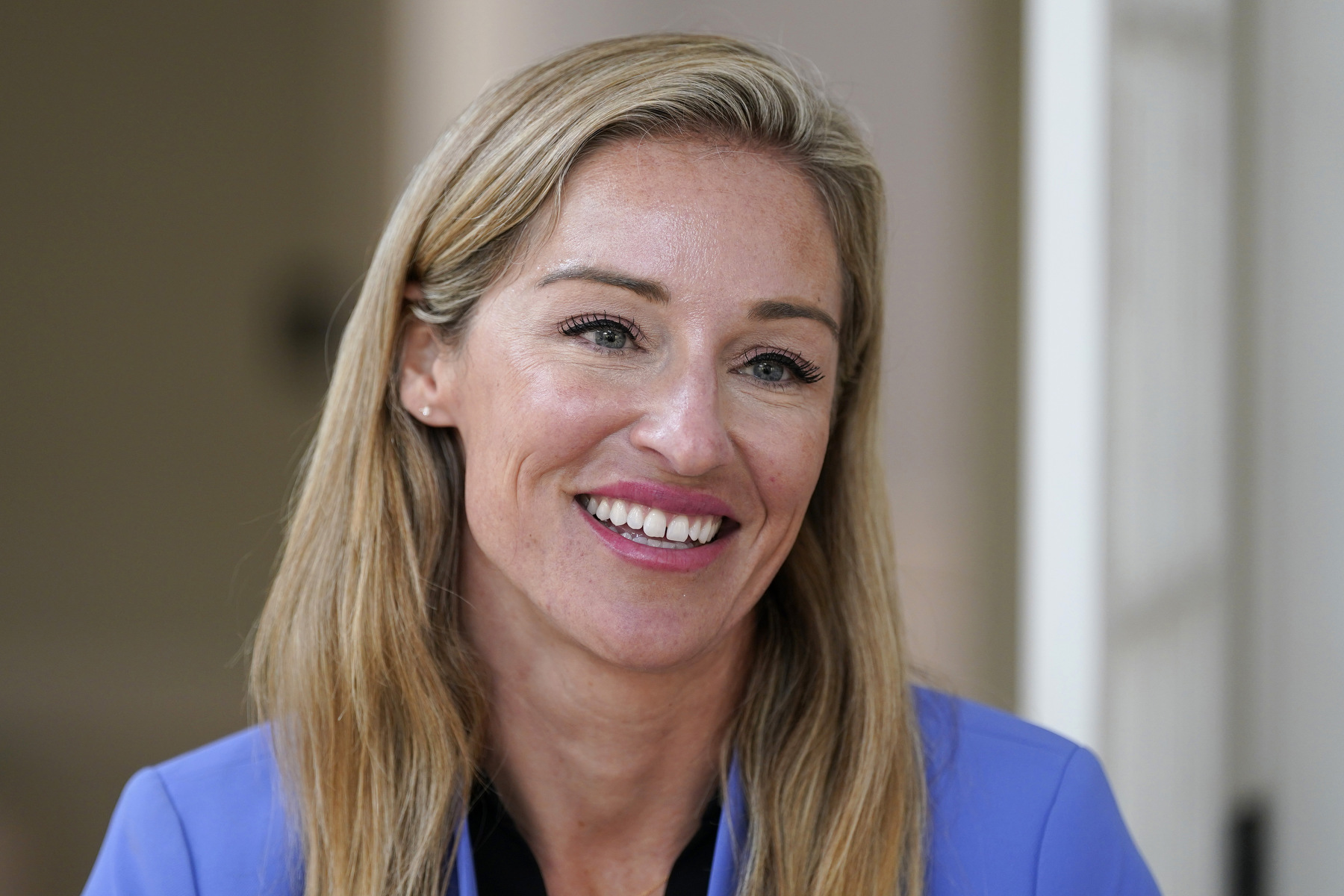 A woman smiles in a closeup portrait.